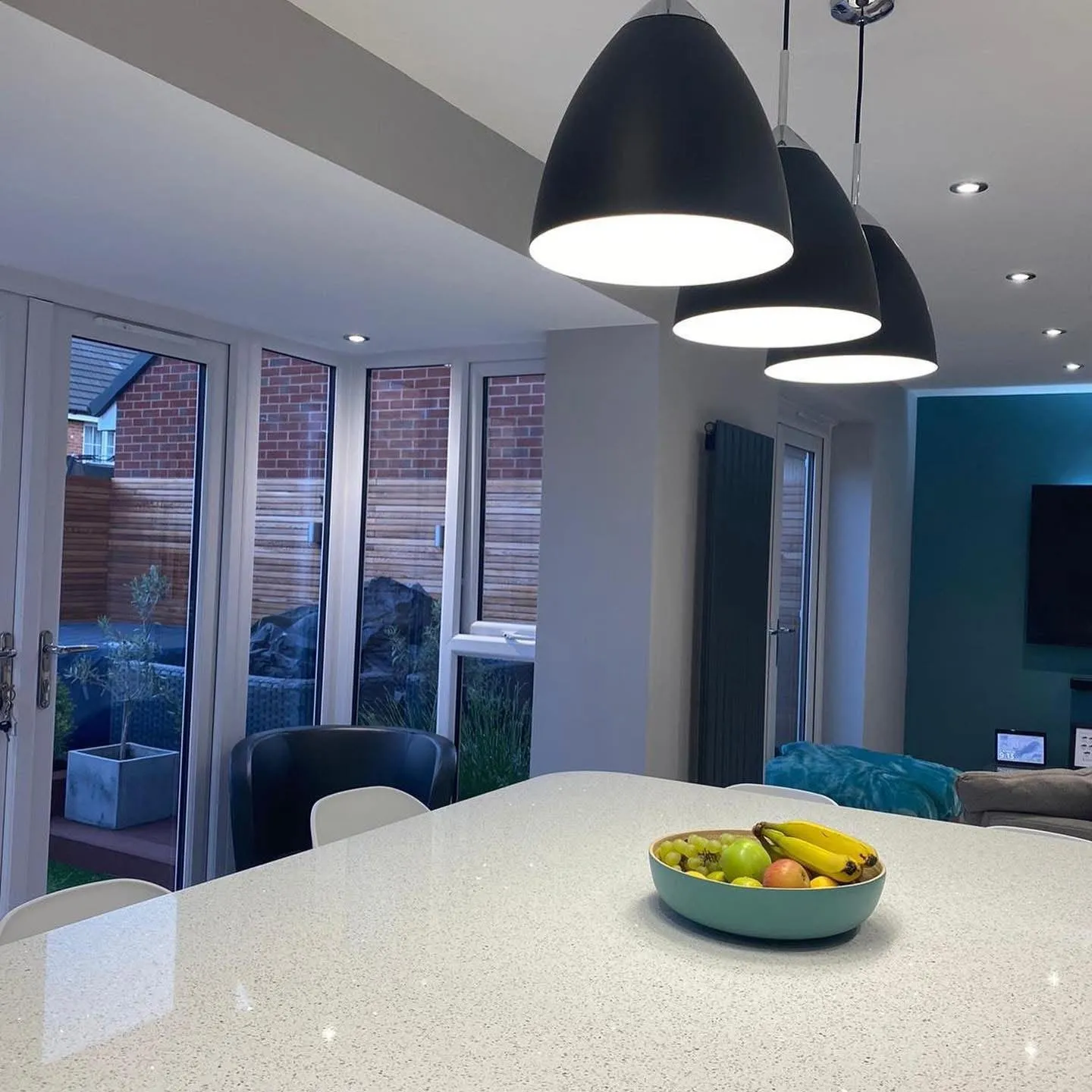 Open plan kitchen and living space renovation with pendant and recessed lighting installed