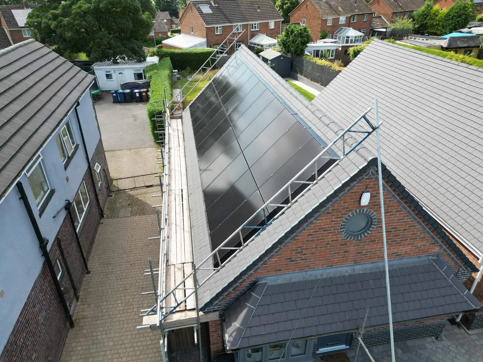 Solar panel installation in progress with scaffolding to a domestic roof
