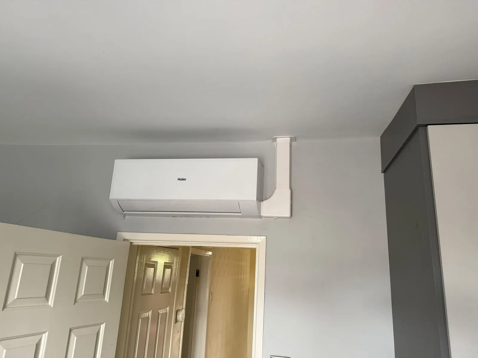 Air conditioning wall unit commissioned and running in a finished interior