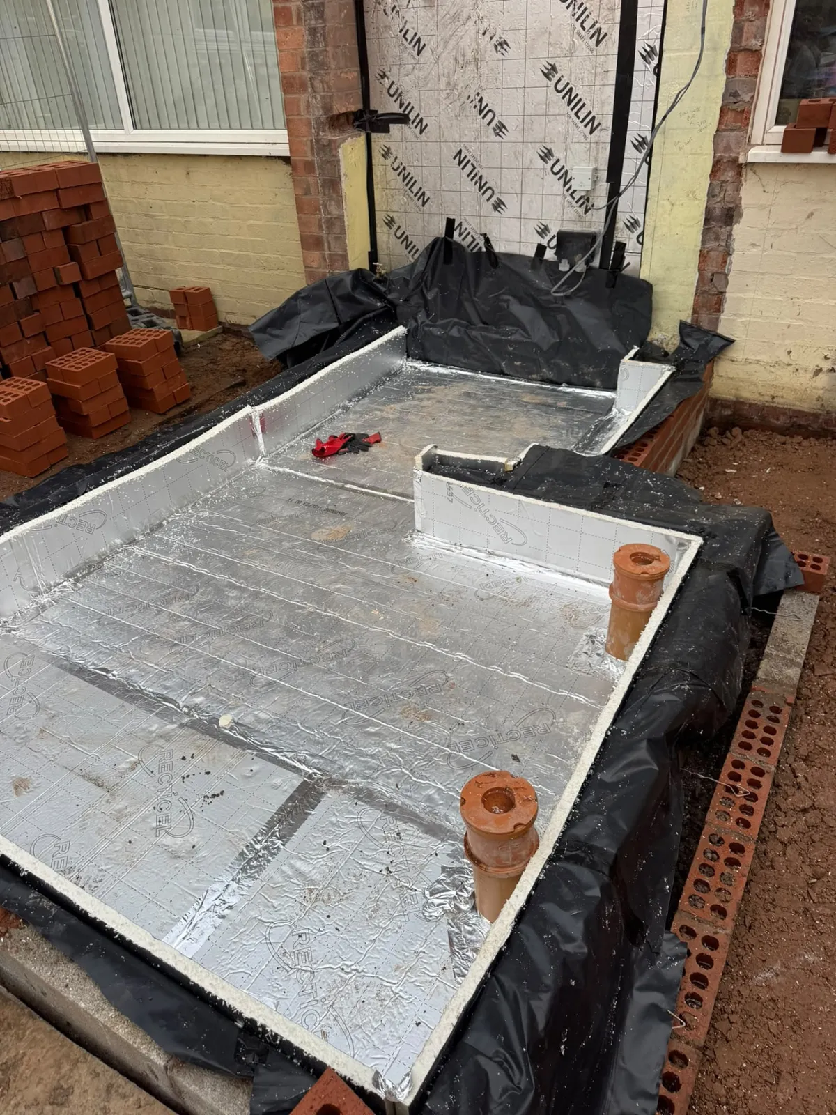 Extension base with insulation and drainage in place before the floor slab is poured