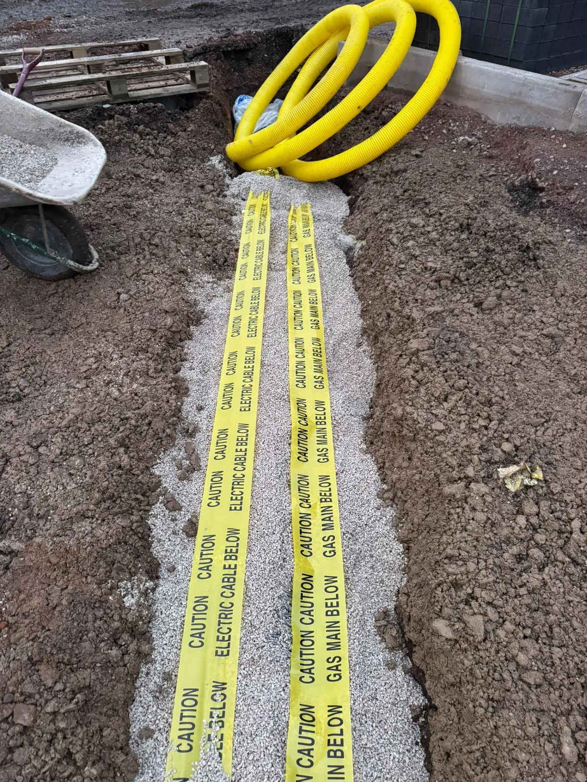 Service ducting and warning tape laid in a trench for incoming supplies