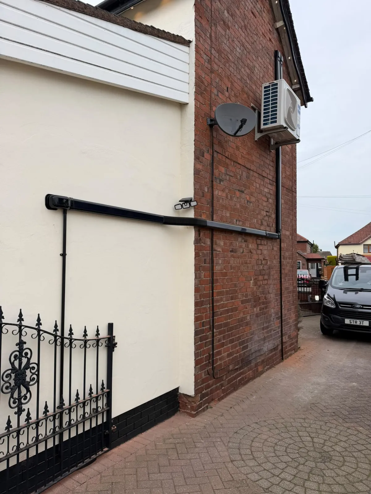 Completed air conditioning outdoor unit installation with tidy pipework and electrical isolation
