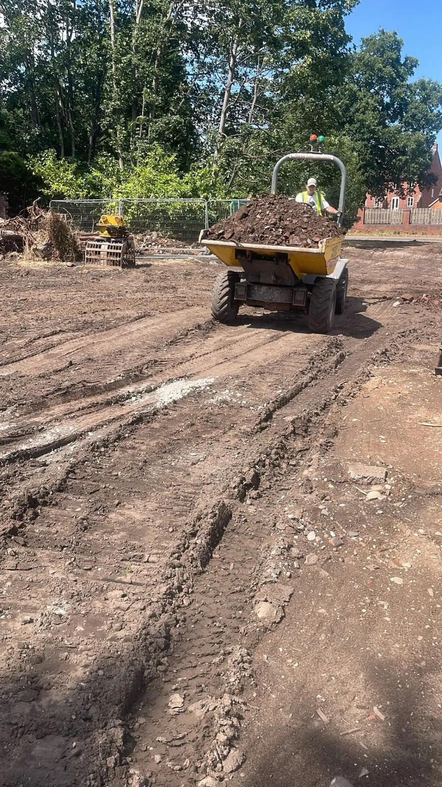 Site clearance in progress with a dumper moving spoil from a stripped site