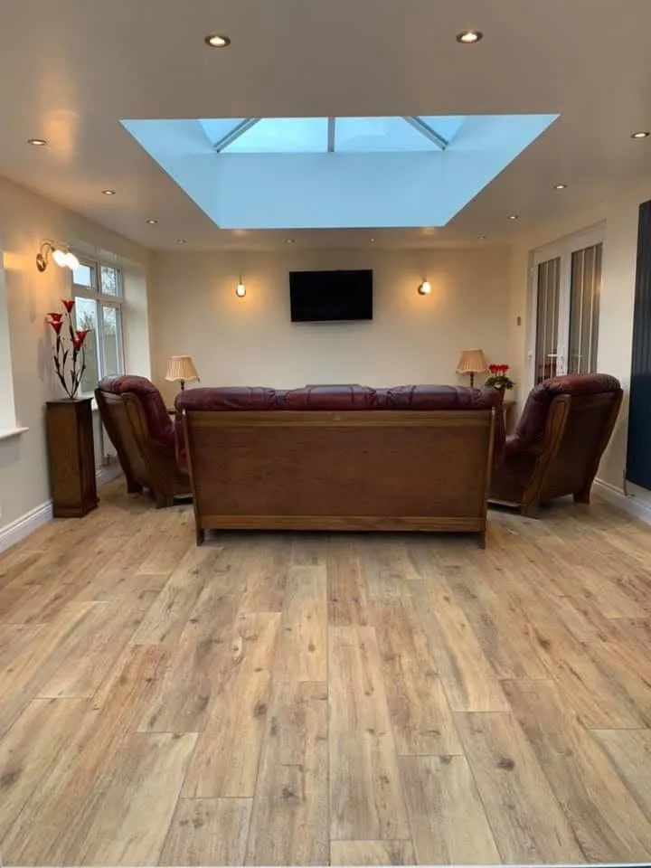 Finished living room renovation with recessed lighting and skylight installed by Stret Limited