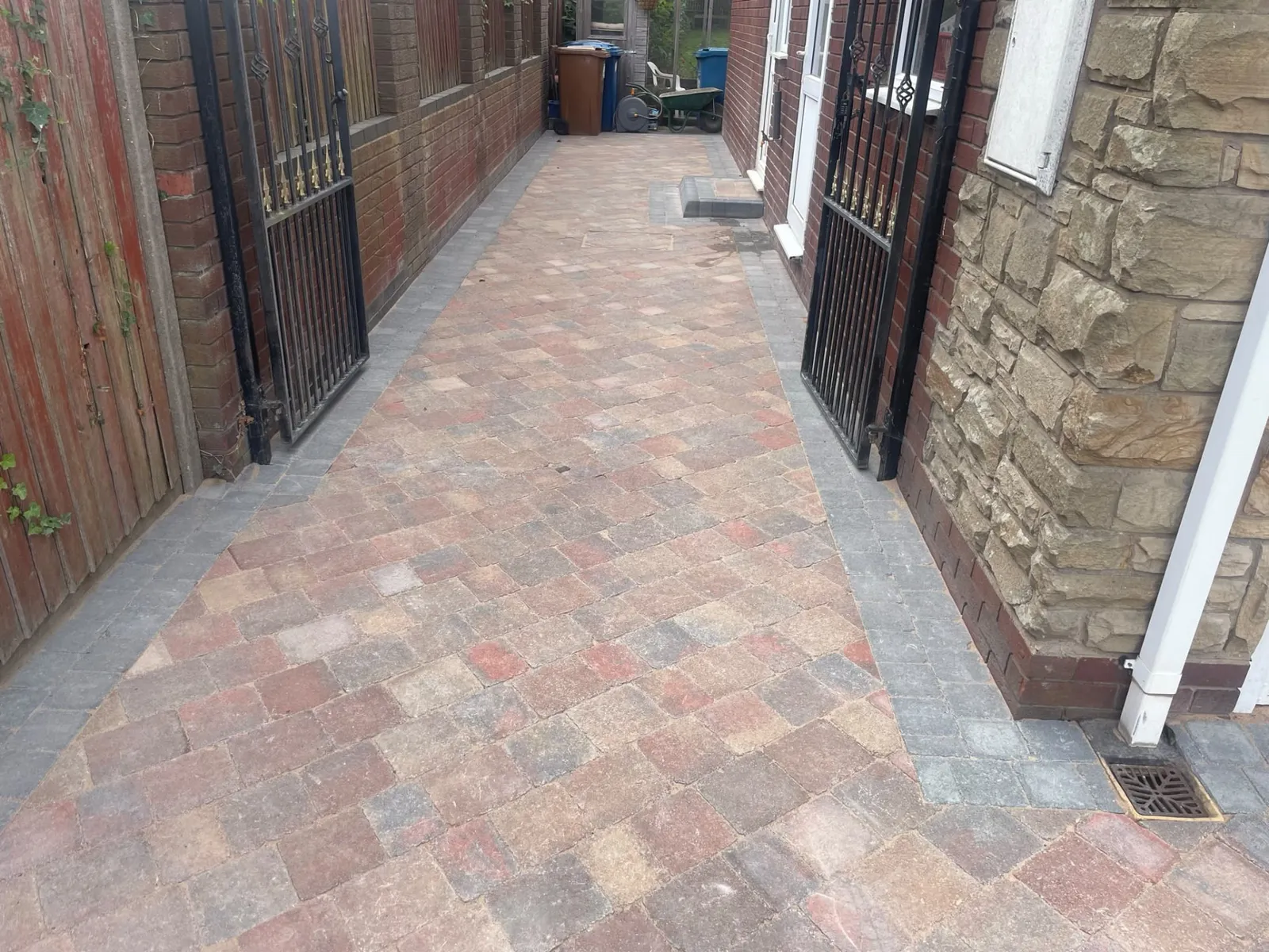 Block paved side pathway completed between brick walls and gates