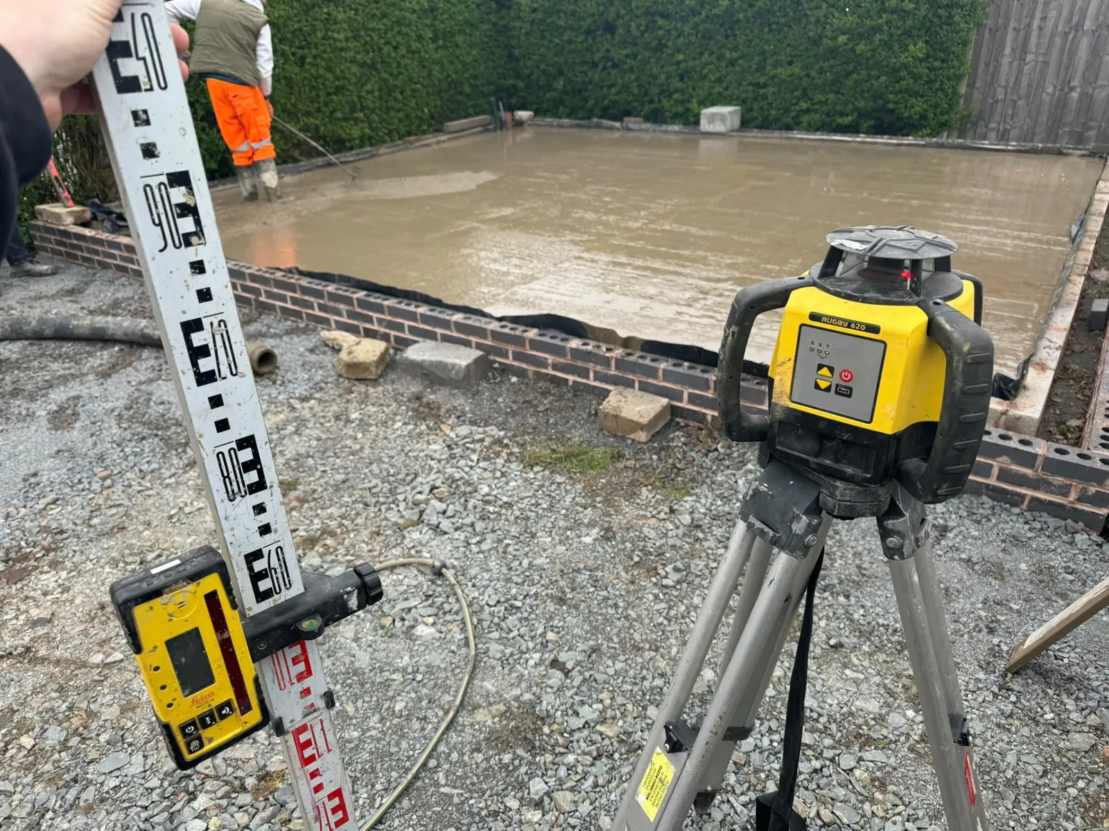 Concrete slab being levelled to laser-checked levels during a groundworks pour